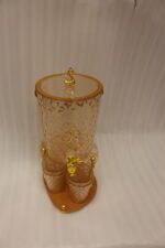 Elegant pink acrylic beverage dispenser with gold swan finial, gold spigot, stand, and 6 matching diamond-cut glasses.