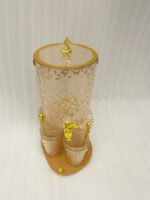 Elegant pink acrylic beverage dispenser with gold swan finial, gold spigot, stand, and 6 matching diamond-cut glasses.