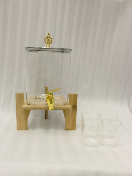 4.2L clear glass beverage dispenser with a gold spigot, gold lid handle, natural wooden stand, and 4 drinking glasses on a kitchen island.