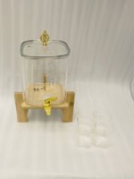 4.2L clear glass beverage dispenser with a gold spigot, gold lid handle, natural wooden stand, and 4 drinking glasses on a kitchen island.