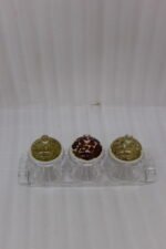 3-piece clear acrylic jar set with patterned dome lids, clear spoons, and serving tray on a kitchen countertop
