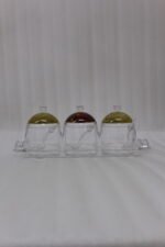 3-piece clear acrylic jar set with patterned dome lids, clear spoons, and serving tray on a kitchen countertop