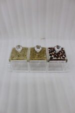 3-piece clear acrylic spice and dry fruit jar set with patterned lids, crystal knobs, and clear tray on marble kitchen counter