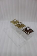 3-piece clear acrylic spice and dry fruit jar set with patterned lids, crystal knobs, and clear tray on marble kitchen counter