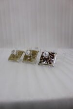 3-piece clear acrylic spice and dry fruit jar set with patterned lids, crystal knobs, and clear tray on marble kitchen counter