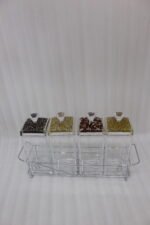 4-piece clear acrylic spice jar set with decorative crystal knob lids arranged in a metal chrome holder on a kitchen countertop