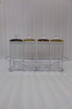 4-piece clear acrylic spice jar set with decorative crystal knob lids arranged in a metal chrome holder on a kitchen countertop