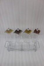 4-piece clear acrylic spice jar set with decorative crystal knob lids arranged in a metal chrome holder on a kitchen countertop