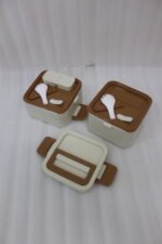 Cream and brown 2-in-1 double-layer portable lunch box with handle sitting on a kitchen counter
