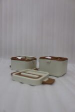 Cream and brown 2-in-1 double-layer portable lunch box with handle sitting on a kitchen counter