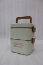 Cream and brown 2-in-1 double-layer portable lunch box with handle sitting on a kitchen counter
