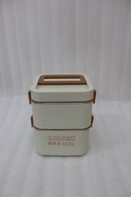 Cream and brown 2-in-1 double-layer portable lunch box with handle sitting on a kitchen counter