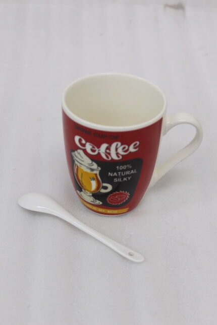 Red ceramic coffee mug with vintage coffee graphic print and matching white ceramic spoon on a kitchen counter