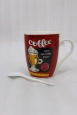 Red ceramic coffee mug with vintage coffee graphic print and matching white ceramic spoon on a kitchen counter