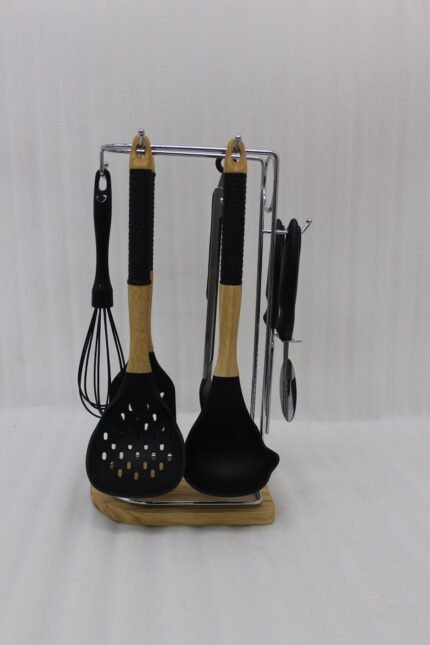 8 piece black silicone kitchen utensil set with wooden handles hanging on a chrome stand