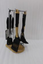 8 piece black silicone kitchen utensil set with wooden handles hanging on a chrome stand