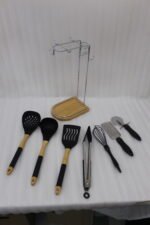 8 piece black silicone kitchen utensil set with wooden handles hanging on a chrome stand