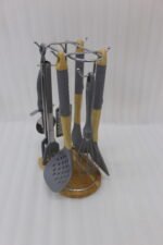 8 pcs grey silicone cooking utensils set with wooden handles hanging on a stainless steel stand with wooden base