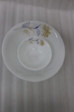 Elegant 32-piece white floral printed dinner set displayed on a marble countertop with plates, bowls, cups, and a platter
