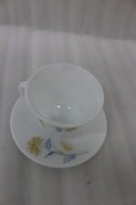 Elegant 32-piece white floral printed dinner set displayed on a marble countertop with plates, bowls, cups, and a platter