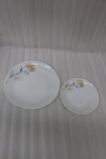 Elegant 32-piece white floral printed dinner set displayed on a marble countertop with plates, bowls, cups, and a platter