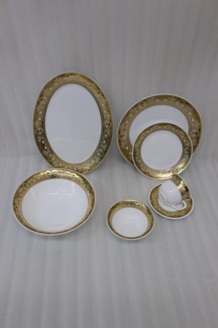 32-piece white porcelain dinner set with embossed gold trim including plates, bowls, cups, and a serving platter