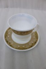 32-piece white porcelain dinner set with embossed gold trim including plates, bowls, cups, and a serving platter