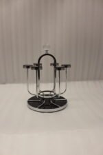 Modern silver chrome glass stand with crystal top finial holding six inverted glasses on a kitchen countertop.