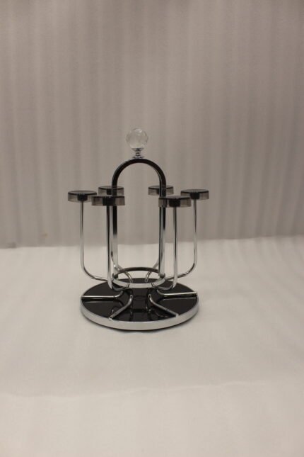 Modern silver chrome glass stand with crystal top finial holding six inverted glasses on a kitchen countertop.