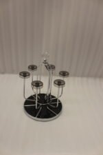 Modern silver chrome glass stand with crystal top finial holding six inverted glasses on a kitchen countertop.