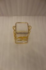 Luxury gold frame spoon stand with fluted clear acrylic container featuring a gold ginkgo leaf emblem on a marble countertop.