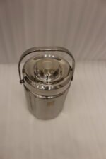 Polished insulated stainless steel lunch box container with a metal carrying handle on a kitchen countertop