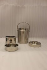 Polished insulated stainless steel lunch box container with a metal carrying handle on a kitchen countertop