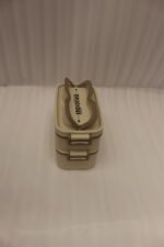 Beige and brown 2 in 1 double layer bento lunch box with locking latches on a kitchen counter