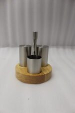 Stainless steel salt and pepper shakers with toothpick holder set in a wooden base on a marble kitchen countertop