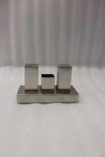 Brushed stainless steel rectangular salt and pepper shaker set with center holder on a matching metal base tray.