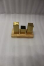 Modern brushed gold stainless steel salt and pepper shaker set with toothpick holder in a wooden base on a kitchen counter