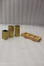 Modern brushed gold stainless steel salt and pepper shaker set with toothpick holder in a wooden base on a kitchen counter