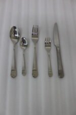 A Diverse Arrangement of Polished Silver-Toned Cutlery on a Textured Linen Mat, Featuring 12-Person Service and Loose Ladles, a Cake Server, and Tongs in the Background.