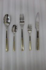72-piece stainless steel cutlery and serving set with dual-tone gold textured handles laid out on a linen cloth.