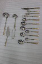 72-piece stainless steel cutlery and serving set with dual-tone gold textured handles laid out on a linen cloth.