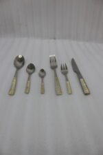 36-piece stainless steel cutlery set with two-tone gold and silver textured handles displayed on a beige napkin.