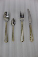 24-piece stainless steel cutlery set with gold-bordered handles including a rice spoon, sweet spoon, fork, and knife arranged on a grey placemat.