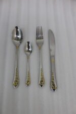 24 piece mirror polish stainless steel cutlery set with ornate gold heart handle detailing on a folded napkin