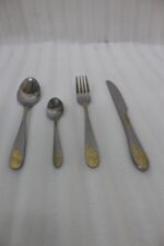 24-piece silver stainless steel cutlery set with gold floral embossed handles displayed on a linen napkin.