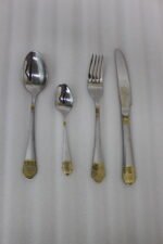 24-piece stainless steel flatware cutlery set with decorative gold handles laid out on a linen cloth