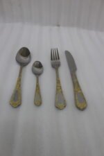 Luxury 24-piece stainless steel cutlery set with ornate gold embossed handles arranged on a linen napkin