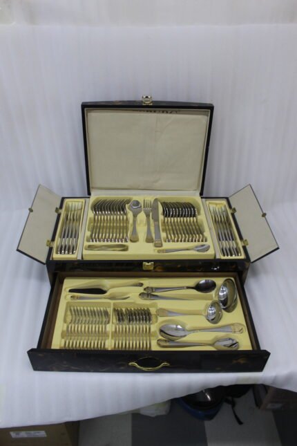 72 piece stainless steel cutlery set with gold detailed handles displayed on a linen mat