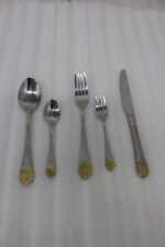 72 piece stainless steel cutlery set with gold detailed handles displayed on a linen mat