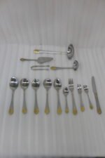 72 piece stainless steel cutlery set with gold detailed handles displayed on a linen mat